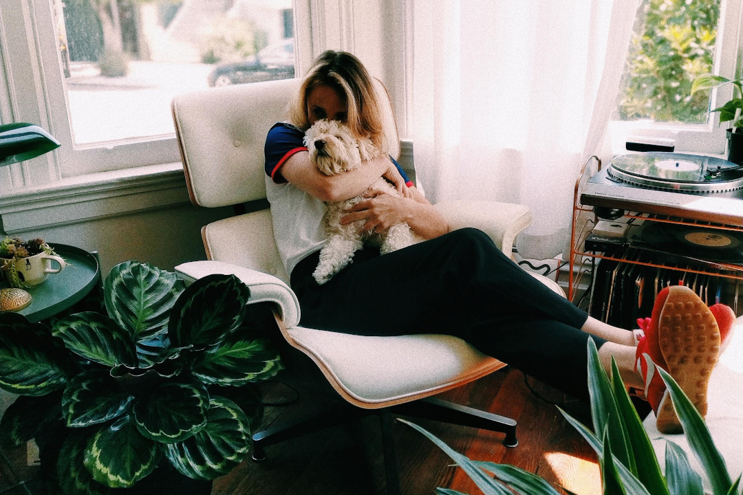 woman relaxing on chair with dog